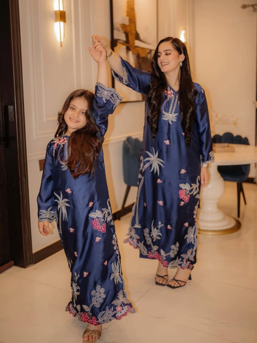ایمن خان سب سے بڑی بیٹی امل منیب کے ساتھ نیلے رنگ میں جڑواں ہو رہی ہیں۔